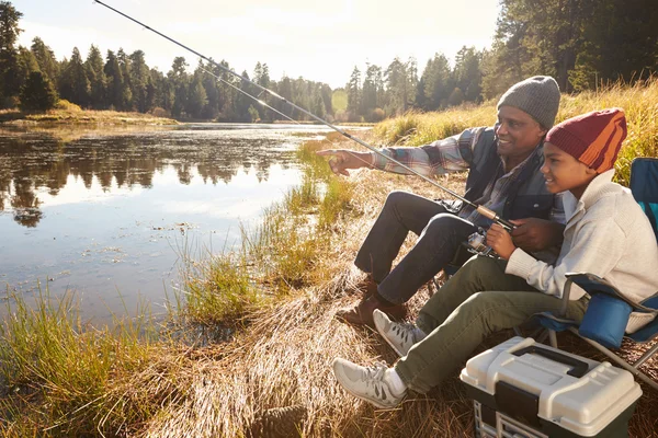 Grand-père enseignant petit-fils à pêcher par le lac — Photo