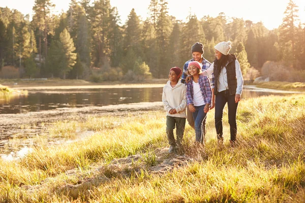 Família caminhando pelo lago — Fotografia de Stock