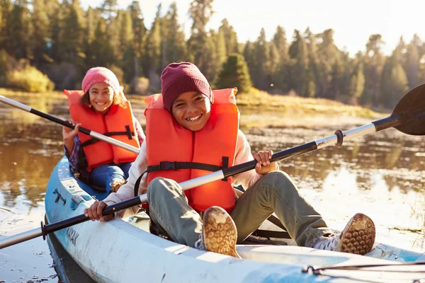 Dos niños remando Kayak en el lago —  Fotos de Stock