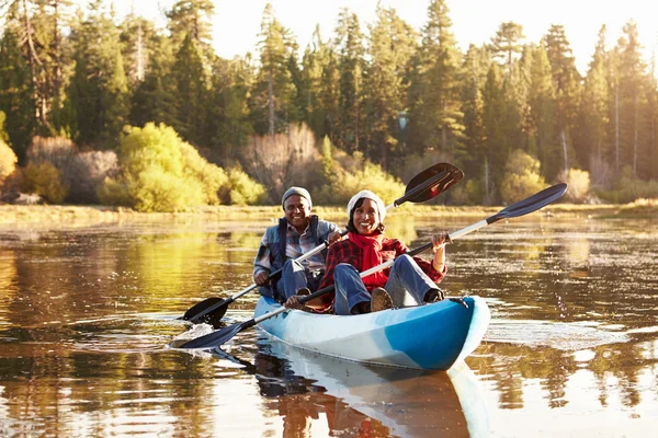 Casal africano remando caiaque no lago — Fotografia de Stock