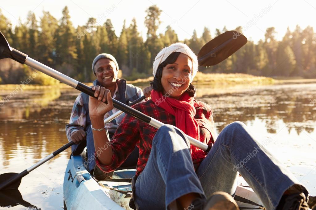 African Couple Rowing Kayak On Lake — Stock Photo © monkeybusiness