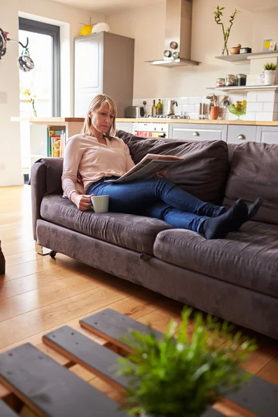 Mulher lendo jornal no apartamento moderno — Fotografia de Stock