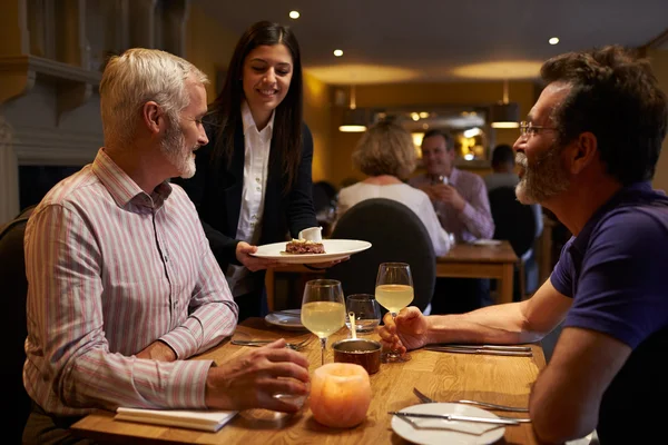 Camarera sirviendo a una pareja masculina en un restaurante — Foto de Stock