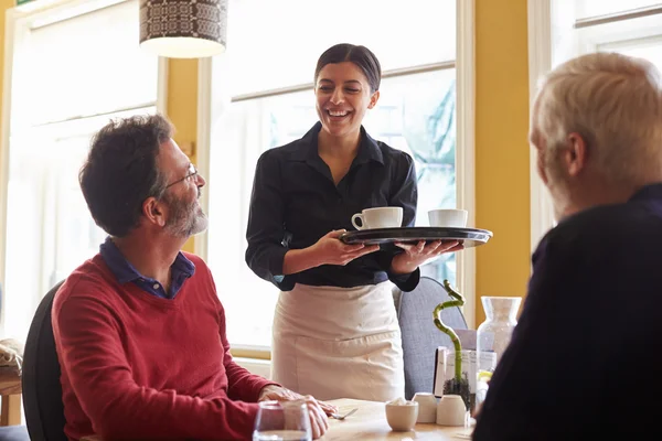 Camarera trayendo café a una pareja masculina — Foto de Stock