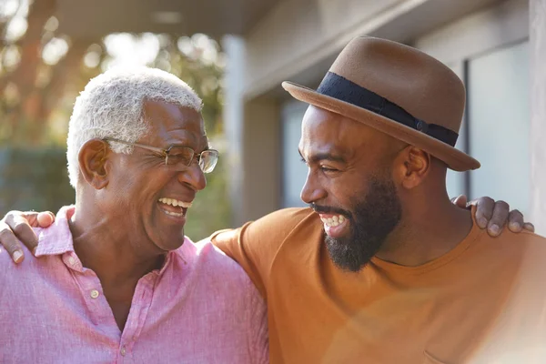 Senior Far Pratar Och Skrattar Med Vuxne Sonen Trädgården Hemma — Stockfoto