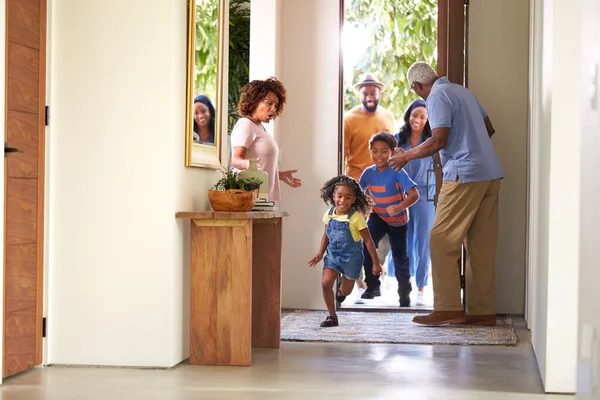 Avós Casa Abrindo Porta Para Visitar Família Com Crianças Correndo — Fotografia de Stock