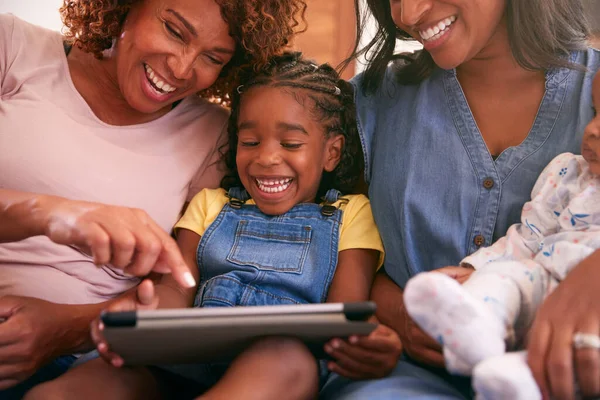 デジタルタブレットを使って自宅でソファに座っている世代のアフリカ系アメリカ人女性 — ストック写真