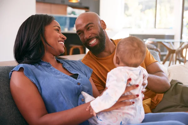 Smiling African American Parents Cuddling Playing Baby Daughter Indoors Sofa — Stock Photo, Image