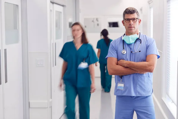 Porträt Von Reif Männlich Doktor Wearing Scrubs Standing Busy Hospital — Stockfoto