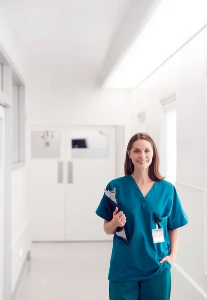 Portret Uśmiechniętej Lekarki Noszącej Szorty Stojącej Szpitalnym Korytarzu Trzymającej Schowek — Zdjęcie stockowe