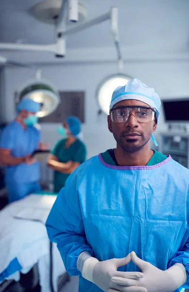 病院の手術室でスクラブや保護眼鏡をかけた男性外科医の肖像 — ストック写真