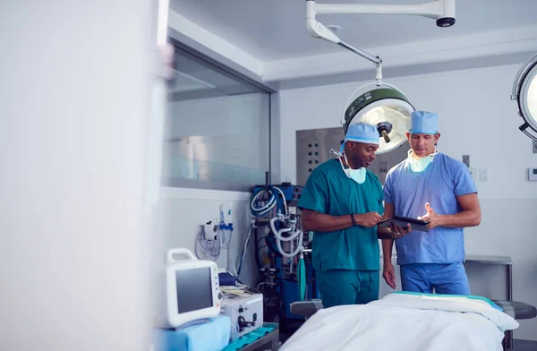 Αρσενικοί Χειρουργοί Φορώντας Γρατζουνιές Κοιτάζοντας Ψηφιακή Ταμπλέτα Στο Χειρουργείο Νοσοκομείο — Φωτογραφία Αρχείου