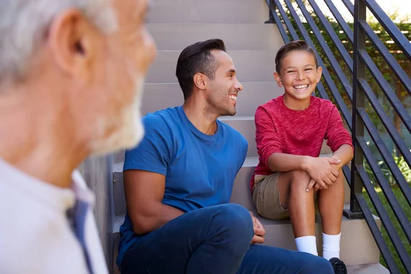 Sorrindo Multi Geração Masculino Família Hispânica Sentados Passos Jardim Conversando — Fotografia de Stock