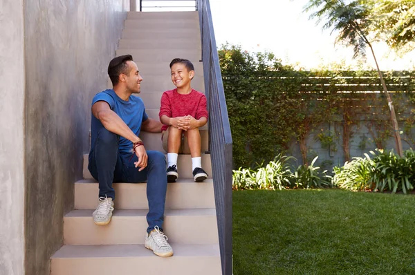 Glimlachende Spaanse Vader Zoon Zitten Stapjes Tuin Samen Praten — Stockfoto