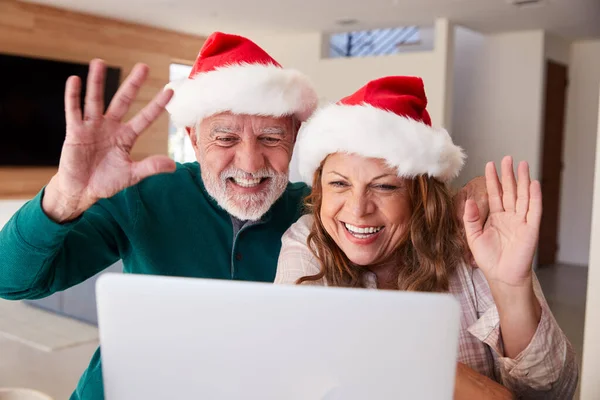 Casal Hispânico Sênior Vestindo Chapéus Papai Noel Com Laptop Conversando — Fotografia de Stock