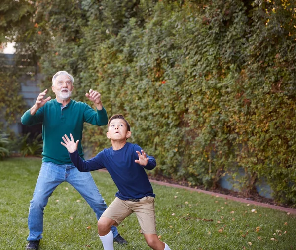 爷爷和孙子在后院等着接球 — 图库照片
