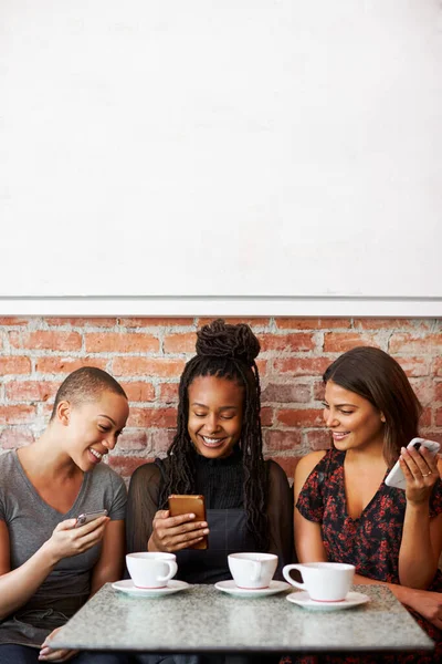Three Female Friends Meeting Coffee Sitting Table Looking Mobile Phones — Stock Photo, Image