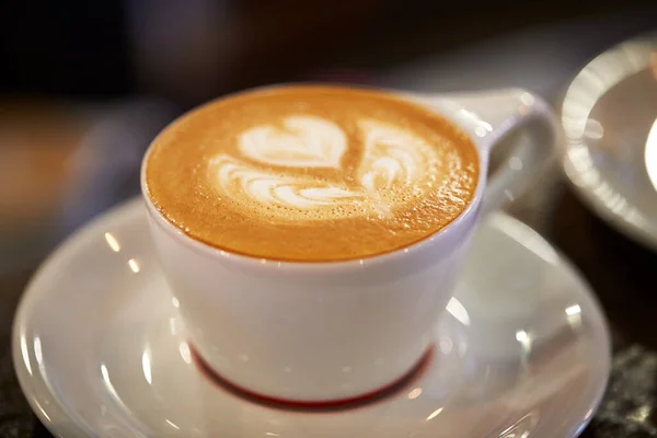 Крупный План Чашки Кофе Дизайном Выливающимся Пену — стоковое фото