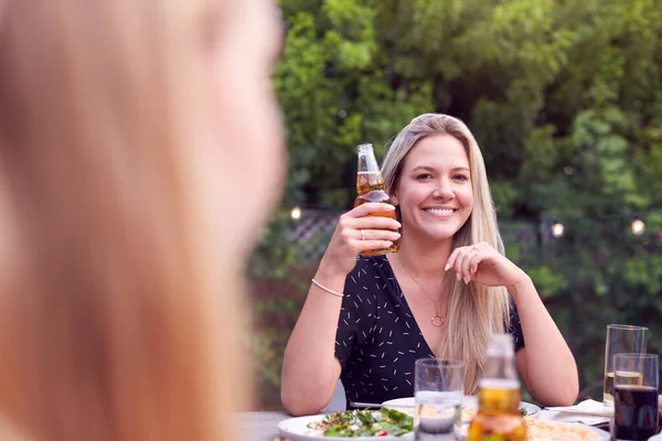 夏のガーデンパーティーを楽しむ自宅で友人と庭でビールのボトルを保持女性 — ストック写真