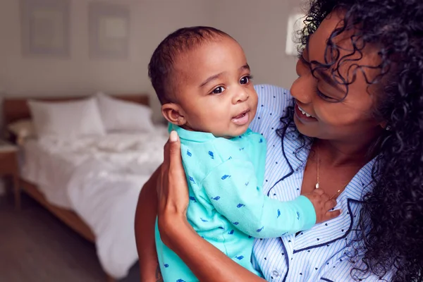 Amar Madre Afroamericana Usando Pijamas Acurrucando Hija Dormitorio Casa —  Fotos de Stock