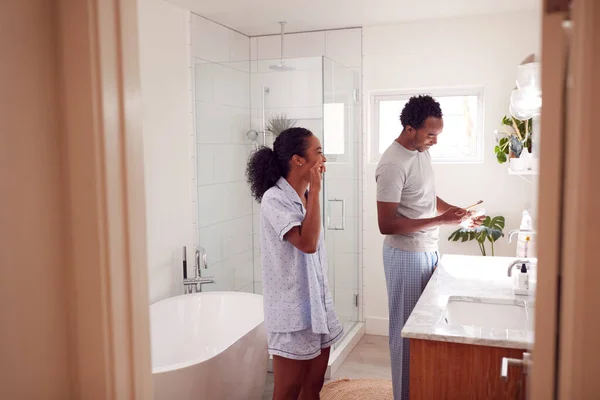 早上穿着睡衣站在洗澡间刷牙的夫妇 — 图库照片