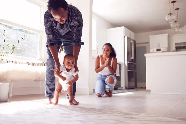 Ouders Moedigen Glimlachende Kleine Dochter Aan Eerste Stappen Zetten Thuis — Stockfoto