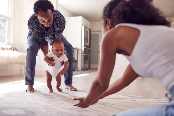 Föräldrar Uppmuntra Leende Bebis Dotter Att Första Steget Och Hemma — Stockfoto