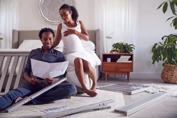 Paar Met Zwangere Vrouw Zoek Naar Instructies Voor Self Assembly — Stockfoto