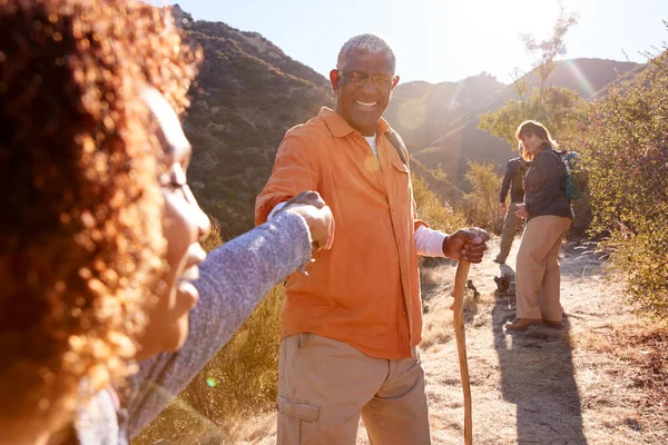 Uomo Aiutare Donna Sul Sentiero Come Gruppo Amici Anziani Andare — Foto Stock