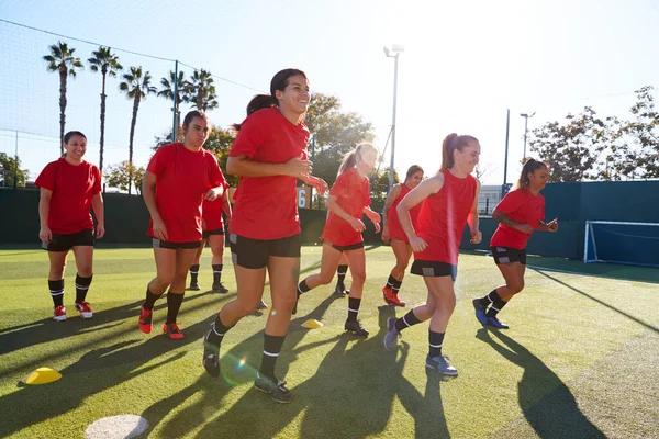 女子足球队在户外运动场地草地球场进行足球比赛训练时奔跑 — 图库照片