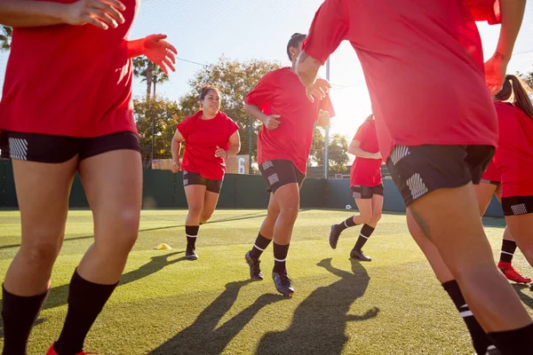 女子足球队在户外运动场地草地球场进行足球比赛训练时奔跑 — 图库照片