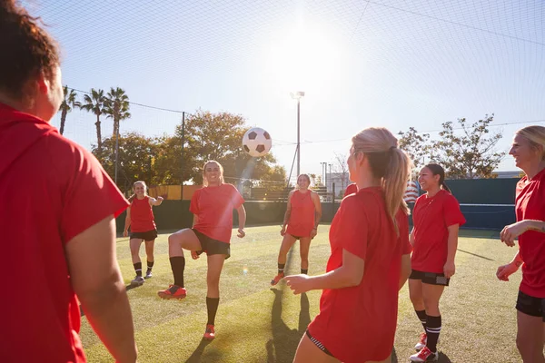 女子足球队在室外草地球场进行足球比赛训练的过程中踢球 — 图库照片