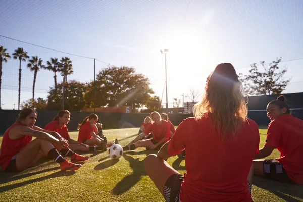 女子足球队在室外露天草地球场足球比赛训练中的伸展动作 — 图库照片