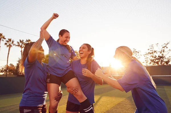 女子足球队庆祝胜利足球赛举重运动员站在肩上 — 图库照片