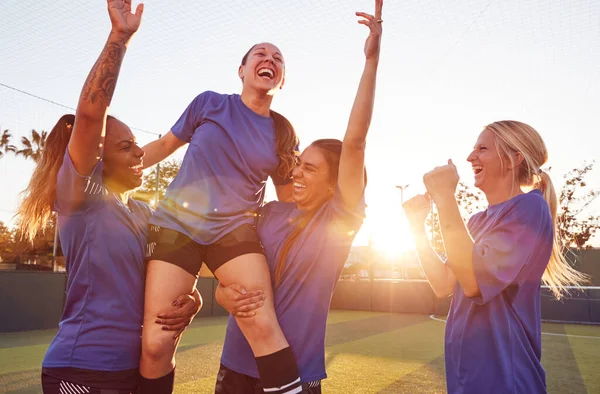 女子足球队庆祝胜利足球赛举重运动员站在肩上 — 图库照片