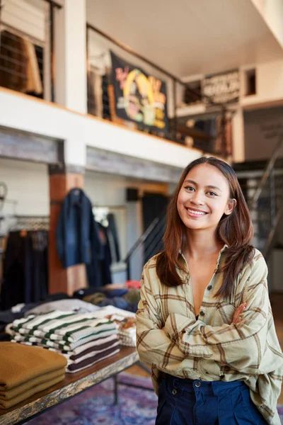 时装店女店主站在服装陈列前笑的画像 — 图库照片