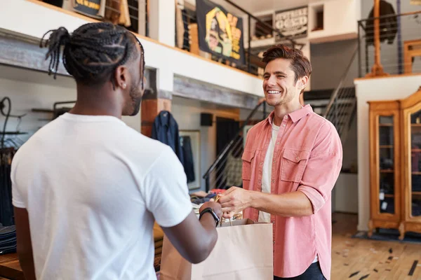 Sales Assistant Handing Purchases Male Customer Fashion Store — Stock Photo, Image