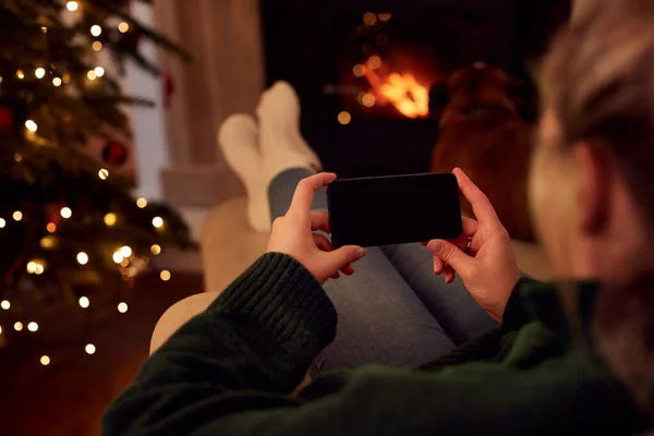 Mujer Casa Usando Teléfono Móvil Con Pantalla Blanco Navidad — Foto de Stock