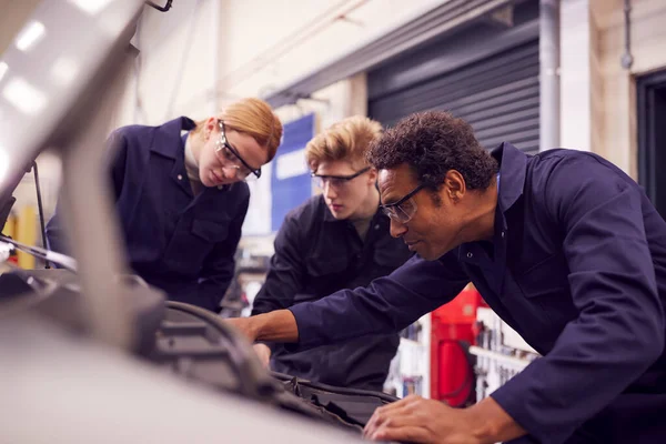 車のエンジンを見ている学生と男性講師 大学での自動機械学習コース — ストック写真