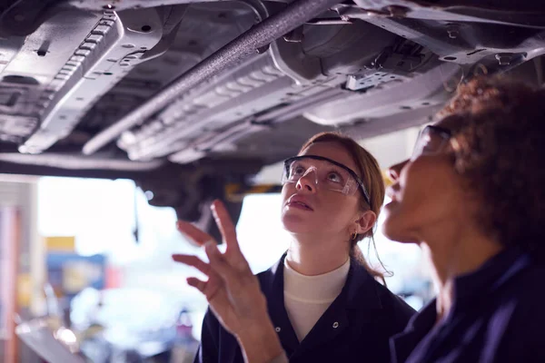 Vrouwelijke Leraar Met Student Zoek Onder Auto Hydraulische Ramp Auto — Stockfoto