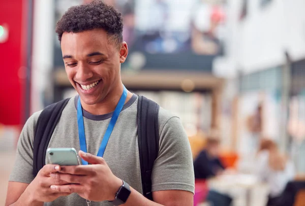 Sonriente Estudiante Universitario Masculino Que Comprueba Teléfono Móvil Ocupado Edificio —  Fotos de Stock