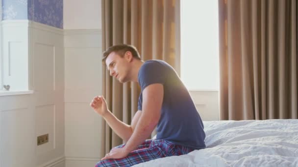 Nieszczęśliwy Przygnębiony Mężczyzna Siedzący Krawędzi Łóżka Domu Podczas Zamknięcia Covid — Wideo stockowe