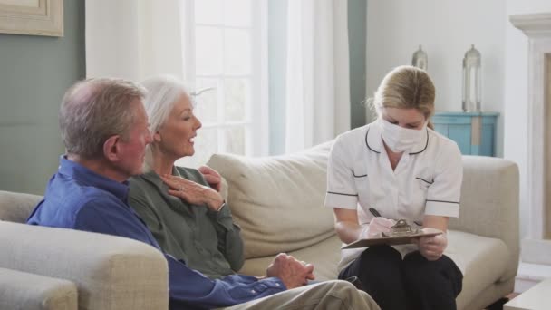 Kobieta Masce Twarz Sprawia Wizyta Domu Starszej Pary Badania Lekarskie — Wideo stockowe