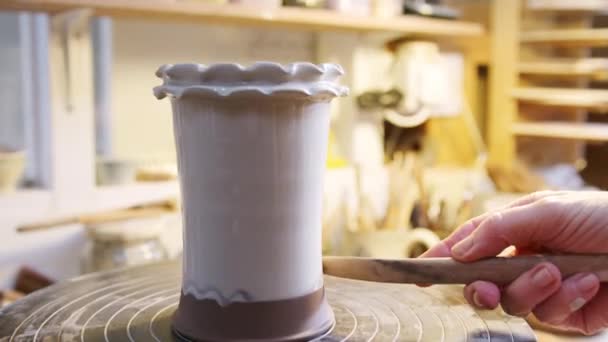 陶芸スタジオのクレイベースにデザインを入れる男性ポッターのクローズアップ — ストック動画