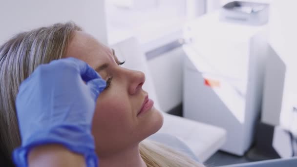 Kobieta Siedząca Krześle Której Lekarz Wstrzykuje Lek Przeciwstarzeniowy Pomiędzy Oczy — Wideo stockowe