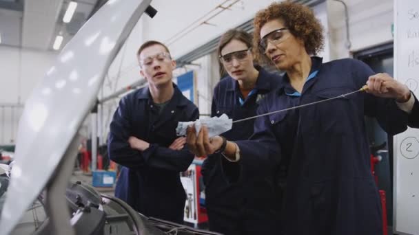 Női Tutor Diákok Ellenőrzése Olajszint Autó Motor Autószerelő Tanfolyam Főiskolán — Stock videók