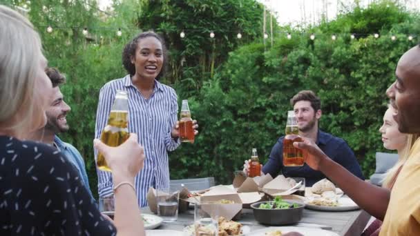 夏のガーデンパーティーを楽しむ自宅で庭でアルコールで乾杯する多文化の友人 スローモーションで撮影 — ストック動画