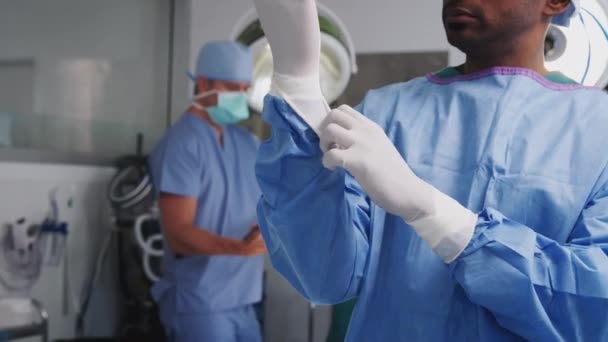 Portret Chirurga Ubranego Fartuch Okulary Ochronne Zakładającego Rękawice Lateksowe Sali — Wideo stockowe