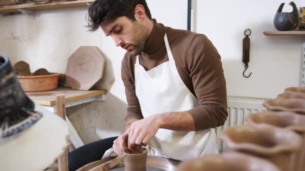 Νεαρός Άνδρας Φορώντας Apron Εργασίας Στο Κεραμικό Τροχό Στο Στούντιο — Αρχείο Βίντεο