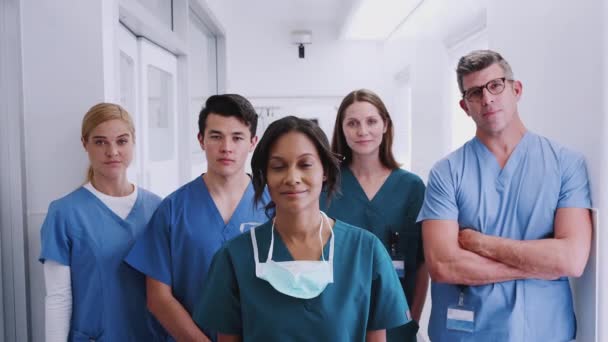 病院の廊下に立つ笑顔の多文化医療チームの肖像 スローモーションで撮影 — ストック動画
